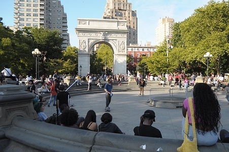 People sit around an empty water fountain in Washington Square Park, Manhattan, New York City.