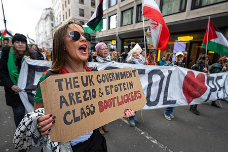A protester holds a placard reading "The UK government Arezio and Epstein class bootlickers" during the rally. Protesters attend a march organized by Together Alliance and House Against Hate in central London, demonstrating against far-right movements and racism. The rally brings together a wide range of communities, organizations and activists, with organizers describing it as one of the largest multicultural demonstrations in UK history. Large crowds gathered with banners, flags and placards calling for unity, equality and opposition to extremism.