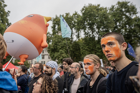Anti-Trump protestors with orange faces seen alongside an orange balloon of the President. Thousands of demonstrators gathered in Parliament Square to protest against Donald Trump’s state visit whilst the President attends a banquet with King Charles at Windsor Castle.