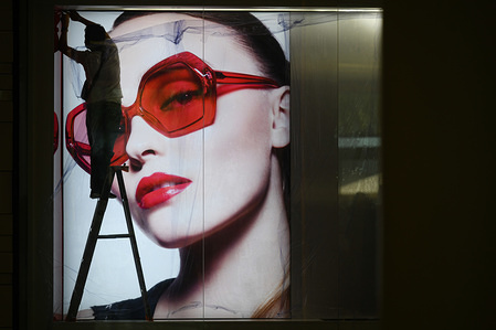 Workers install an advertisement of a luxury fashion brand during the reopening preparations at Siam Paragon shopping mall.
After two month of Thailand shutdown due to the Covid-19 crisis. Shopping malls will reopen to the public with strict health and safety measures on May 17th.