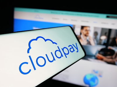 In this photo illustration, a smartphone with the logo of British payroll services company CloudPay Inc is seen on screen in front of website.