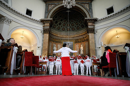 The conductor of the Belarusian Free Choir (Volny Chor) performs during the Pray for Ukraine event at the St. Alexander's Church in Warsaw. The Free Choir (Volny Chor) is a symbol of Belarusian protest. It is a community of Belarusian musicians, artists and people whose voices were heard throughout 2020 – 2021 in Belarus and abroad as a protest against Belarusian regime and to support the people who fight the regime. Their first performance was on August 25, 2020 at the Stolitsa Shopping Center in Minsk, Belarus. For a couple of months they performed in shopping malls, at the train stations, opera house and other venues in the city. After the detaining and the wave of repression on people participating in the choir many were forced to leave Belarus. 
For security reasons, the Free Choir (Volny Chor) hide their faces, despite now staying in Poland. They sing Belarusian songs as well as poetry. After the Russian invasion of Ukraine, the choir has sung Ukrainian national songs and the Ukrainian anthem to show solidarity.
