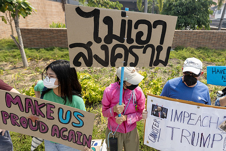 Anti-war protesters hold handmade placards expressing their opinions during a CNX4PEACE demonstration outside the U.S. Consulate General.