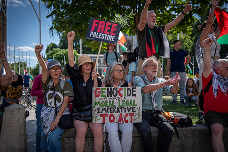 Protestors rally with flags and placards at Parliament Square during the National March for Palestine – Stop Starving Gaza – Stop Arming Israel in central London. Following the Home Secretary's decision to proscribe Palestine Action as a terrorist organization in July 2025, over 500 supporters, organized by Defend Our Juries, gathered in Parliament Square, holding signs reading, “I oppose genocide. I support Palestine Action.” The protesters staged a sit-down demonstration, defying the ban and challenging police to arrest them for expressing support for the proscribed group.