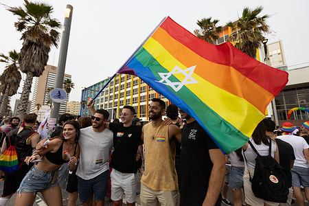 A group of people poses with an LGBT flag during the Tel Aviv LGBT Pride parade. Tel Aviv Pride 2023 was the last major, large-scale pride celebration before the traditional parade was disrupted by regional events. The 2023 parade was a massive success, drawing roughly 150,000 to 200,000 participants to celebrate along the Mediterranean promenade.