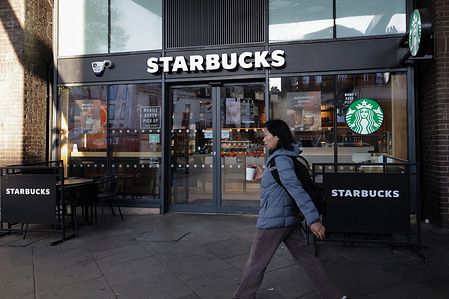 A woman walks past a branch of Starbucks in London.