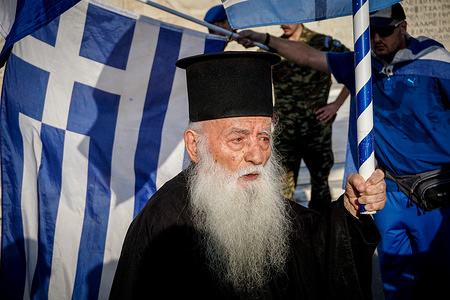 An orthodox priest holds a Greek flag during a protest against the recent agreement between Greece and Macedonia. Macedonia and Greece have ended a 27-year-old dispute by signing a historic agreement that changes the name of the former Yugoslav republic to the Republic of North Macedonia.