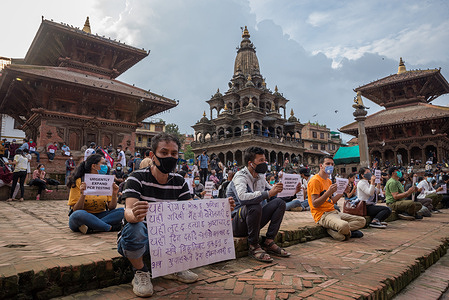 Protester holding a placard while wearing a face mask during the demonstration.
Nepalese people have gathered at Patan Durbar Square to protest peacefully under covid 19 precautions, against the government's in-efficiency in handling the coronavirus pandemic crisis.