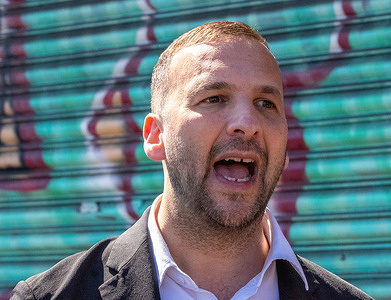 Zack Polanski speaks in front of a graffiti covered closed up shop. Green Party announced a three-step plan to boost High Streets. Green Party leader, Zack Polanski, and Green MP for Gorton and Denton, Hannah Spencer walked along the High Street Levenshulme, Stockport Road in Manchester, meeting members of the public and shop keepers.