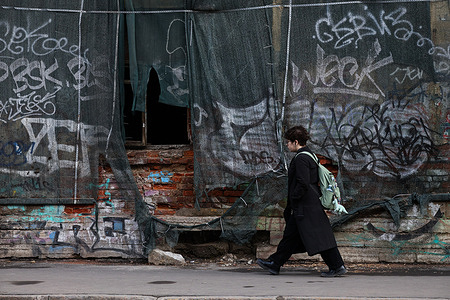 A girl walks in front of an abandoned building in St. Petersburg. St. Petersburg experienced unusually warm weather for mid-March this weekend. Temperatures reached 15 degrees Celsius. Residents flocked to the streets, filling parks, embankments, and central squares.