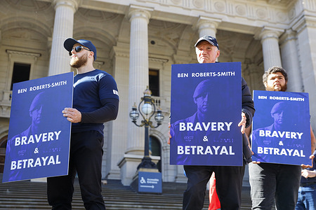 Protesters hold placards during the rally. Supporters marched in Melbourne in support of Ben Roberts-Smith, calling for charges against him to be dropped and expressing solidarity with current and former members of the Special Air Service Regiment. A separate anti Ben Roberts-Smith protest was held nearby. Roberts-Smith is currently facing five war crime murder charges over alleged killings of unarmed Afghan civilians during deployments in Afghanistan and remains on bail while the case proceeds through court.