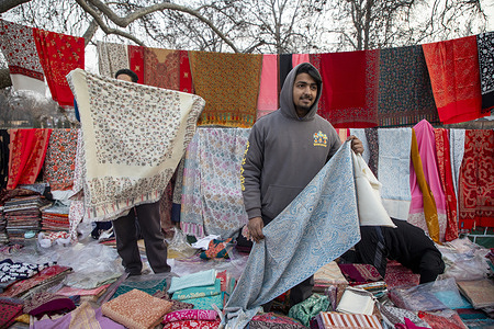 A Kashmiri vendor displays warm shawls for sale at the Sunday market on a cold winter day in Srinagar, Indian-administered Kashmir. The Sunday Market in Srinagar draws thousands of people each week who come to buy everyday necessities, turning central streets into a dense stretch of vendors and shoppers. The market has long been part of the city’s routine and remains a crucial source of income for local street sellers who depend on its weekly trade.
