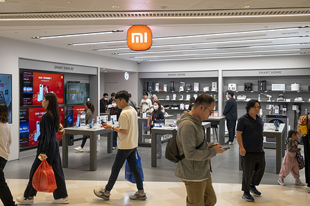 Pedestrians and shoppers walk past the Chinese multinational technology and electronics brand Xiaomi store in Hong Kong.