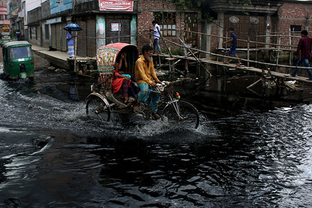 A rickshaw goes over dyed and polluted water that is being released into a canal that leads to the Buriganga river in Dhaka.
Some canals in Dhaka city are completely filled up by dumping garbage and may not be recovered anymore and rest of the other canals and river contain pitch black water with noxious fume.