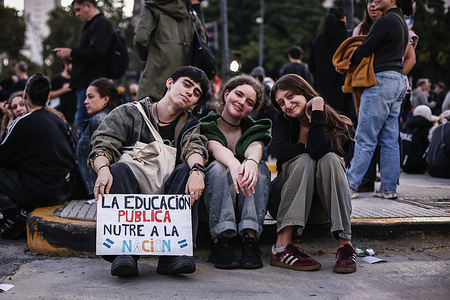 Protesters sit with a placard saying “Public education nourishes the nation” during the demonstration. Thousands of people participated in a new march in defense of public education and universities. The protesters are demanding the implementation of the teacher funding law that was passed but has not yet been applied.