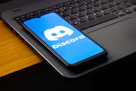 In this photo illustration, the Discord logo is seen displayed on a smartphone screen.