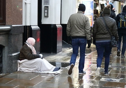 A homeless person seen seating on the cold and wet pavements of London.