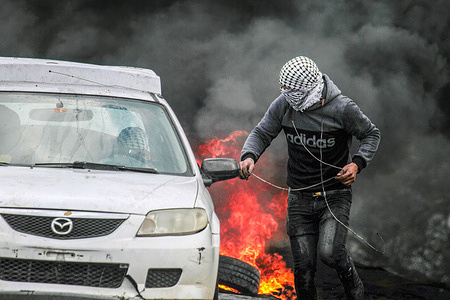 Palestinian demonstrators burn tires, during the demonstration against Israeli settlements in the village of Kafr Qaddum near the West Bank city of Nablus.