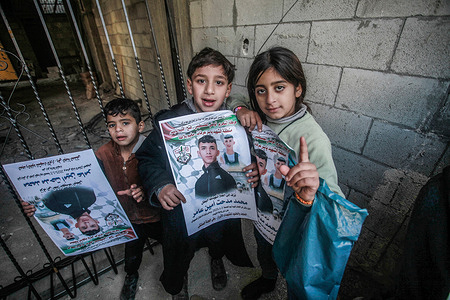 Palestinian children hold pictures of the Palestinian young man, Mohammed Amer (18 years old), after he was killed by Israeli army bullets during their raid on Balata camp. Eight Palestinians were injured, four of them in critical condition and were transferred to Nablus Hospital.