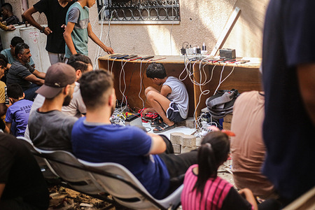 A Palestinian boy sits under the table inside the Al-Amal Hospital of the Palestinian Red Crescent Society to charge his mobile phone following the Israeli airstrike in Khan Yunis in the southern Gaza Strip. Many Palestinians have sought refuge in a United Nations-run school in Khan Yunis in the southern Gaza Strip, amid the ongoing hostilities. The conflict began on Oct 7, when Palestinian Hamas militants based in Gaza launched a surprise attack in southern Israel, prompting Israel to declare war on Hamas in Gaza. The situation in the Gaza Strip and Israel has led to a significant loss of life, with thousands of people from both sides affected since the surprise attack.