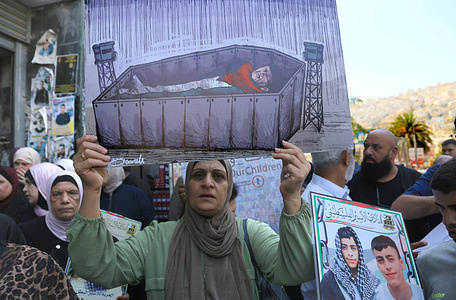 A Palestinian woman holds up a sign depicting a coffin containing a body draped in the Palestinian flag during a demonstration organised by Palestinian families in the West Bank city of Nablus. The families, carried signs and photos of their loved ones, demanded the return of their remains, which are held in Israeli cemeteries. Palestinian sources revealed that among the remains of 799 young people in the West Bank are those 99 prisoners, who died in Israeli prisons, including 10 Palestinian women.