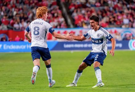 Vancouver Whitecaps FC Defender Mathias Laborda (2) and Vancouver Whitecaps FC Midfielder Oliver Larraz (8) celebrate a goal during the MLS regular-season match between Chicago Fire and Vancouver Whitecaps FC at Soldier Field. Final Score: Chicago Fire 3:1 Vancouver Whitecaps FC