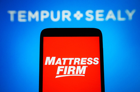 In this photo illustration, Mattress Firm Inc. logo is seen on a smartphone and Tempur Sealy International logo in the background. Bedding provider Tempur Sealy has agreed to acquire Mattress Firm in a cash-and stock-transaction valued at about $4 billion.
