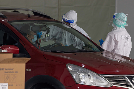 A health worker in personal protective equipment (PPE) takes a swab sample from a man in the car, a rapid antigen test amid the COVID-19 outbreak at the COVID-19 drive-through site at Liberty Square in Taipei. Taipei City opened up a drive-through service for COVID-19 testing at Liberty Square, allowing for 1,200 tests to be administered.
