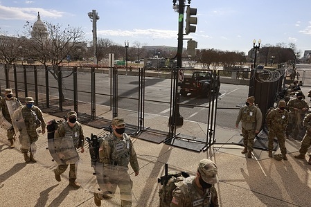 National Guard troops march near the United States Capitol building after the inauguration of President Joe Biden and Vice President Kamala Harris. 
The Capitol was breached during an insurrection January 6 just days before the inauguration.