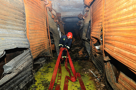 A firefighter inspects at the fire site in Old Dhaka's Armanitola.
Four persons were killed and 23 were injured, including fire service officials, in a fire at a building in Old Dhaka's Armanitola area early today.