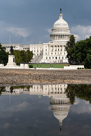 The U.S. Capitol is reflected in a puddle in Washington.
