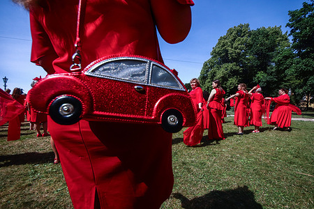 A woman participant in the flash mob 'Project in Red Dresses' at the Alexander Garden with a red handbag. As the organizers of the event write: In 2024, the “Project in Red Frocks” supports the decree of Russian President Vladimir Putin “On holding the Year of the Family in the Russian Federation.” Family is the basis of any society and an important part in a person’s life. It is in this social unit that a harmonious personality is formed. The family gives a person confidence, a sense of support, the knowledge that in this huge world there are people who wait, love and accept a family member with his personal characteristics, advantages and disadvantages. “The Red Dress Project” allows women to reveal their potential at any age, remind them of beauty through women, and charge men with the energy of femininity and natural beauty!