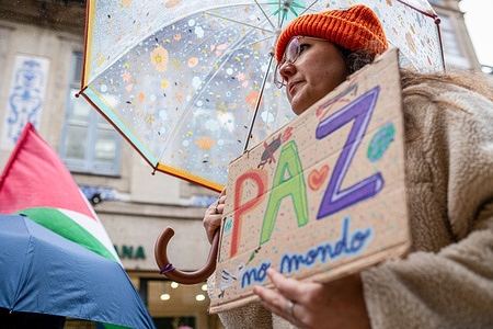 A protester holds a colourful placard saying "Paz no mondo" during the demonstration calling for peace, sovereignty and solidarity, organized by several Portuguese groups.
