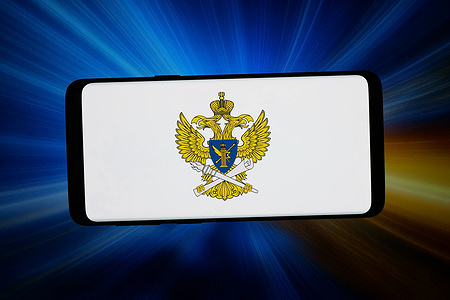 In this photo illustration, the logo of Russian regulation agency Roskomnadsor (RKN) is displayed on a smartphone in front of abstract background on computer screen.