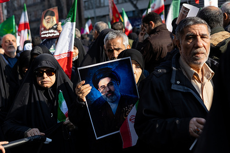 A woman seen holding a poster of Mojtaba Khamenei, the new Supreme Leader and son of Ayatollah Ali Khamenei.