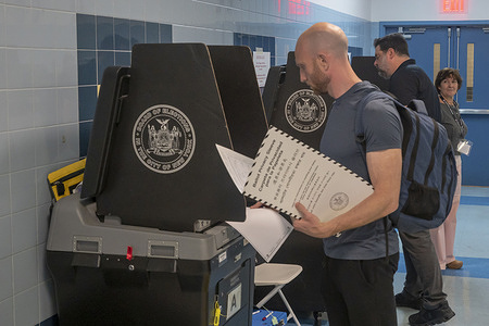 NEW YORK, NEW YORK - NOVEMBER 05: People enter ballots to scanners on National Election Day for the U.S. Presidential election at P.S./I.S. 78Q on November 05, 2024 in the Long Island City neighborhood of Queens borough in New York City. Voters will decide between Republican Presidential Candidate Former President Donald Trump and Democrats Presidential Candidate Vice President Kamala Harris as to who will be the next President of the United States of America.