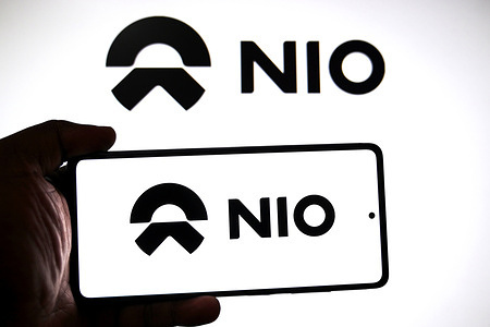 In this photo illustration, a Nio ink logo is seen displayed on a smartphone and in the background.