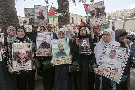 Mothers of Palestinian prisoners hold pictures of their imprisoned sons during a solidarity rally in the West Bank city of Nablus. Palestinians stage a protest demanding a prisoner exchange agreement with the Israeli government and Hamas.