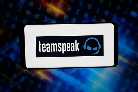In this photo illustration, the logo of voice communication software TeamSpeak (TS) is displayed on a smartphone in front of abstract background on computer screen.