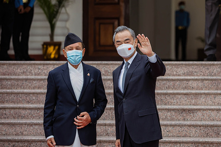 Nepalese foreign minister Narayan Khadka (L) and Chinese Foreign Minister Wang Yi wave as they arrive to attend the meeting. A Memorandum of Understanding (MoU) has been signed between the two sides for financial and technical assistance, feasibility study of the transmission line projects, and a team of Chinese health workers providing services in Nepal.