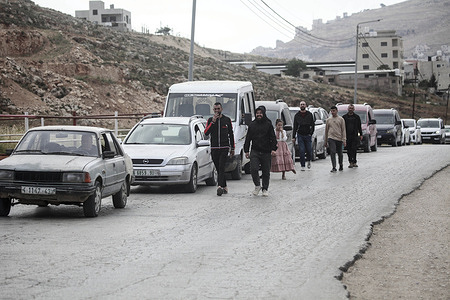 Palestinians walk past vehicles at a checkpoint around the West Bank city of Nablus. Israeli army forces closed military checkpoints south and east of Nablus following the injury of an Israeli soldier near the village of Beita during clashes. Palestinian sources said that an Israeli ambulance was seen transporting an injured soldier.