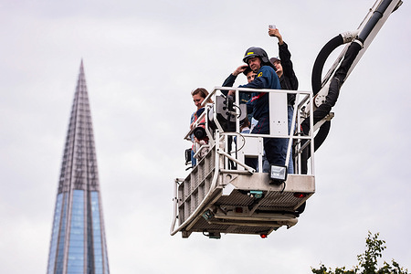 People ride in the cradle of a fire truck during the firemen's festival in the 300th anniversary park against the backdrop of the building of the public and business complex with the headquarters of the Gazprom group Lakhta Center. On June 14, the festival “My Dad is a Fireman, My Dad is a Hero” was held in the park for the 300th anniversary of St. Petersburg. Visitors were treated to interactive platforms, spectacular demonstrations by rescuers extinguishing a burning car, as well as a concert program and a field kitchen.