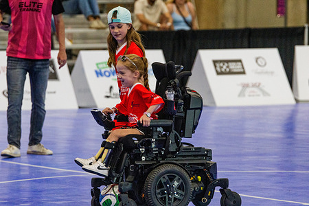 A young participant in a wheelchair carries the ball up the court during "Kicks for Dreams" at Edmonton Expo Centre. "Kick for Dreams" is a fundraising futsal marathon benefiting Alberta Dreams, a non-profit organization that grants wishes to children living with severe chronic or terminal illnesses. Organized by media personality Chris Scheetz, local athletes and community figures played continuously for 72 hours at the Edmonton EXPO Centre during the KDays festival, setting a new world record for the longest futsal match.