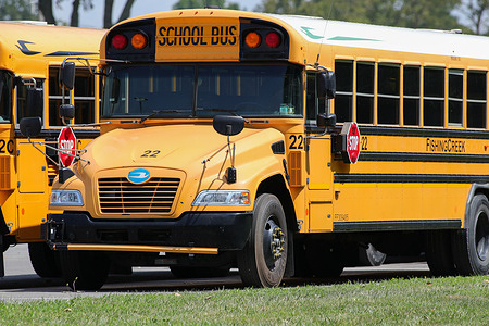 Yellow school buses are parked on the campus of Bloomsburg Area High School.