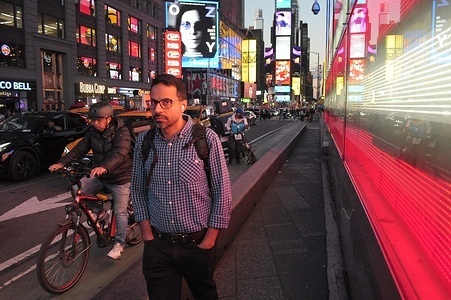A man walks past a lighting installatio in Times Square.