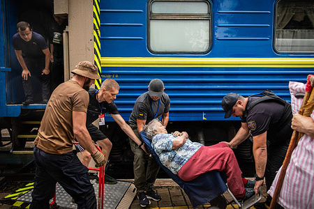 Volunteers help a woman with walking disabilities to board the evacuation train at the Pokrovsk Train Station. Amid the intensified fighting in the Eastern part of Ukraine, east Ukraine is now strengthening its civilian evacuation. Millions of Ukrainian families are relocated to the western part of the country. According to the United Nations, at least 12 million people have fled their homes since Russia invaded Ukraine, while seven million people are displaced inside the country.