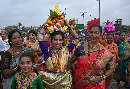 Fisherwoman carries a pot on her head with a coconut on the top during the Narali Poornima (coconut day) celebration in Mumbai. The Hindu fishing community in coastal region of Maharashtra offers coconuts and praying to the ocean for a safe fishing season. Singing and dancing is the main event during the celebration along with preparation of sweet coconut rice on the day.