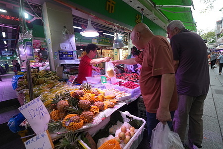 People shop at a market on Fengyuan Main Street in Guangzhou. Daily life in Guangzhou, China