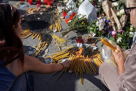 Two mourners light candles up during the commemoration ceremony outside the Novi Sad railway station. Hundreds of thousands of mourners gathered for the first commemoration for the Novi Sad's tragedy, in Serbia. The mourning people laid flowers and wreaths outside the train station. The tragedy happened when on 1st of November 2024 the concrete canopy of the railway station collapsed and killed 16 people.