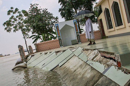A man stands on the partially broken Mosque caused by River erosion in Munshiganj.
One third of Bangladesh is under water after some of the heaviest rains in a decade leaving more than 3 million people affected with homes and roads in villages flooded, Flood Forecasting and Warning Centre (FFWC) officials said.